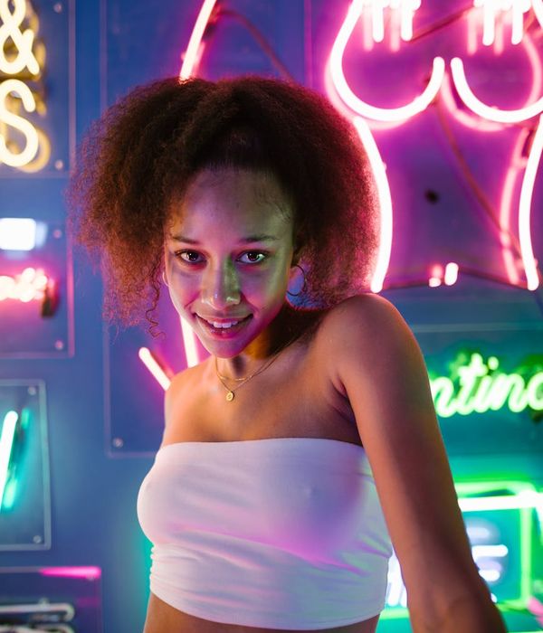 Energetic woman in motion against a dark, stylish background.