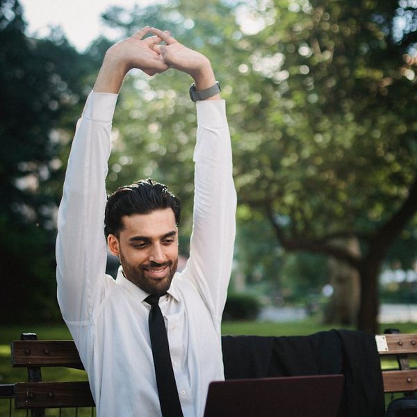 Smiling person stretching outdoors, feeling refreshed and balanced.